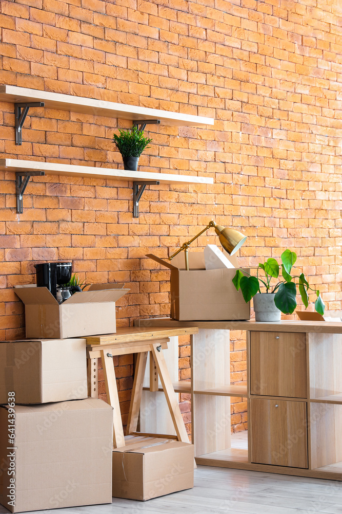 Interior of stylish office with cardboard boxes on moving day