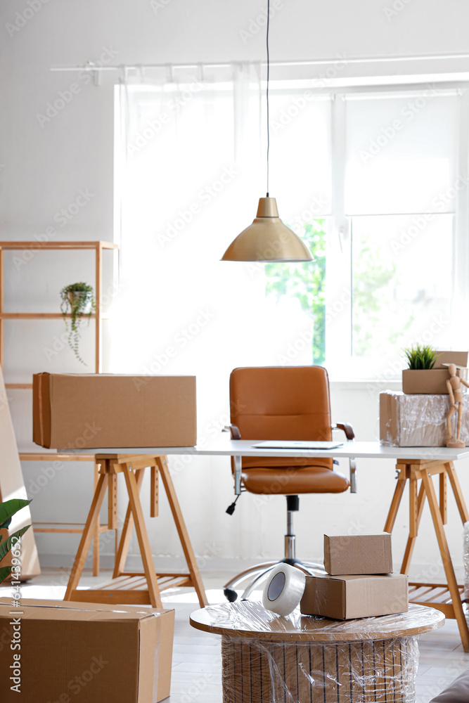 Interior of stylish office with cardboard boxes on moving day