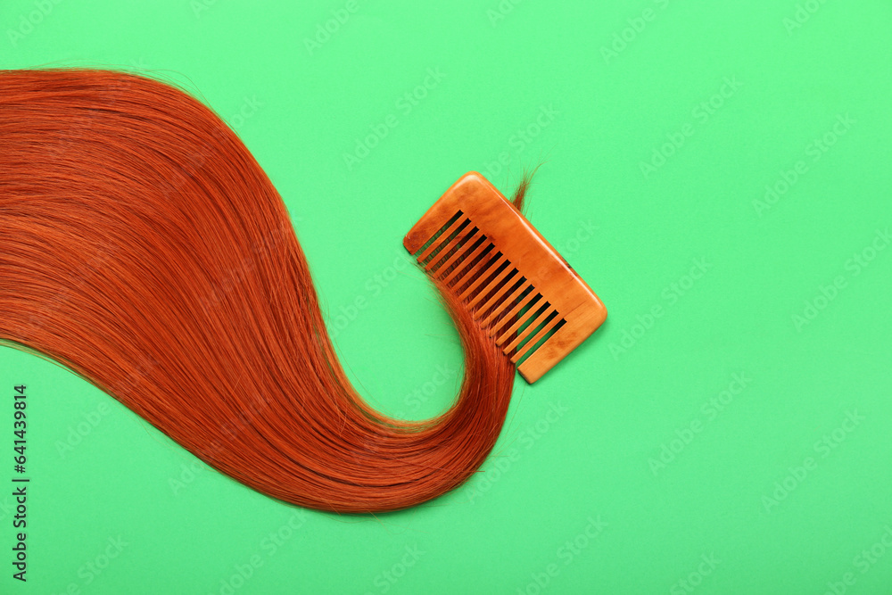 Beautiful ginger hair with comb on color background