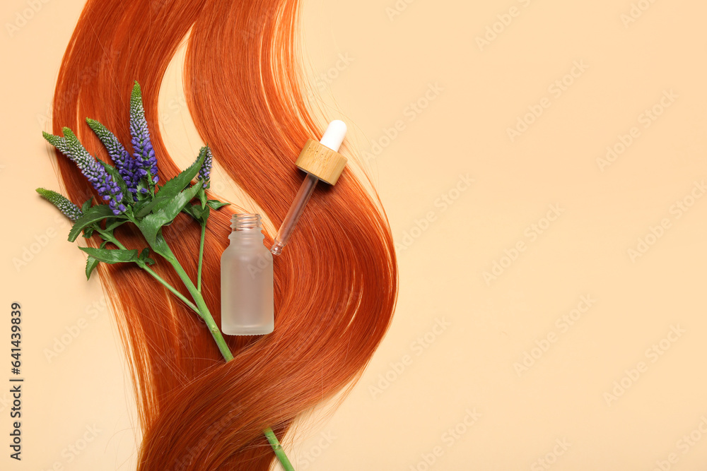 Ginger hair strand, flowers and bottle of essential oil on color background