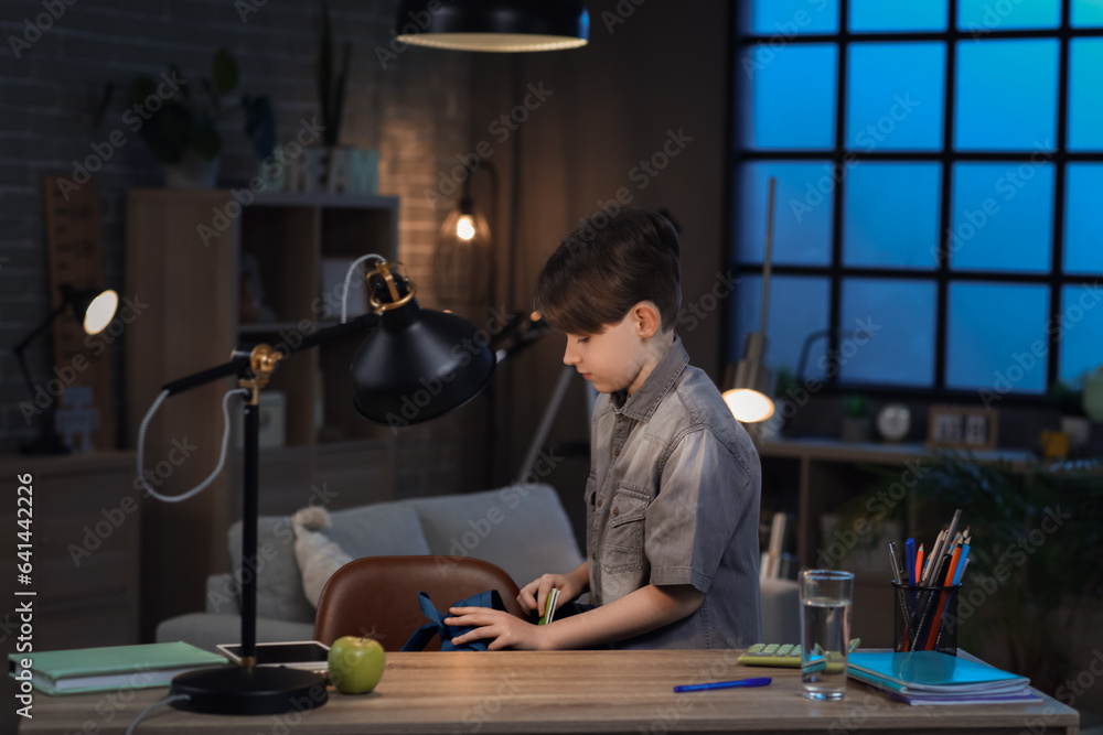 Little boy preparing for school at home in evening