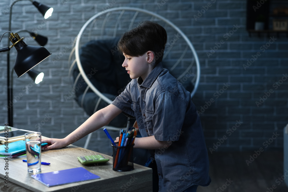 Little boy preparing for school at home in evening