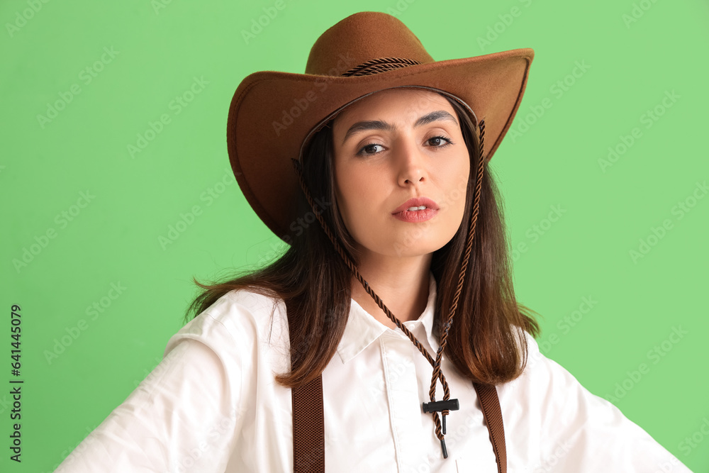 Beautiful cowgirl on green background, closeup