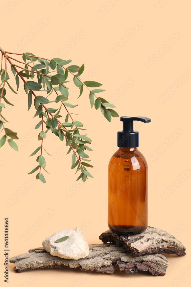 Bottle of cosmetic product, tree bark and eucalyptus branch on color background