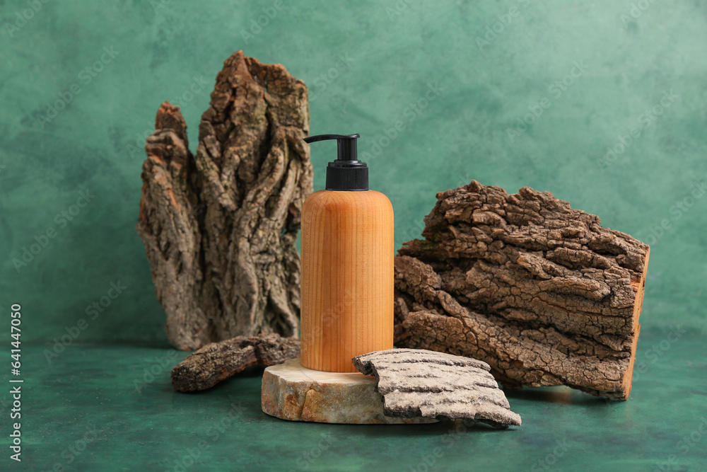 Composition with bottle of cosmetic product and tree bark on color background