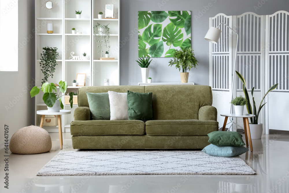 Interior of light living room with green sofa and houseplants