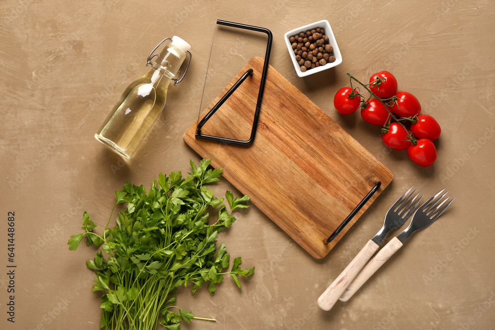 Composition with wooden kitchen board, spices, oil, parsley and tomatoes on color background