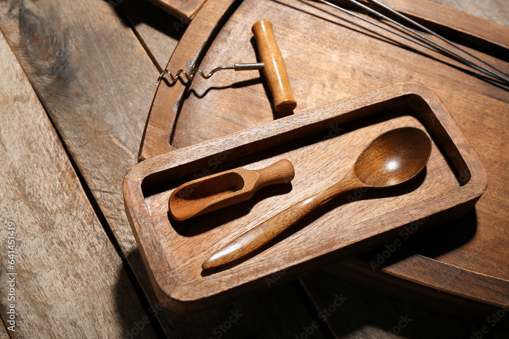 Different cutting boards, scoop and spoon on wooden background