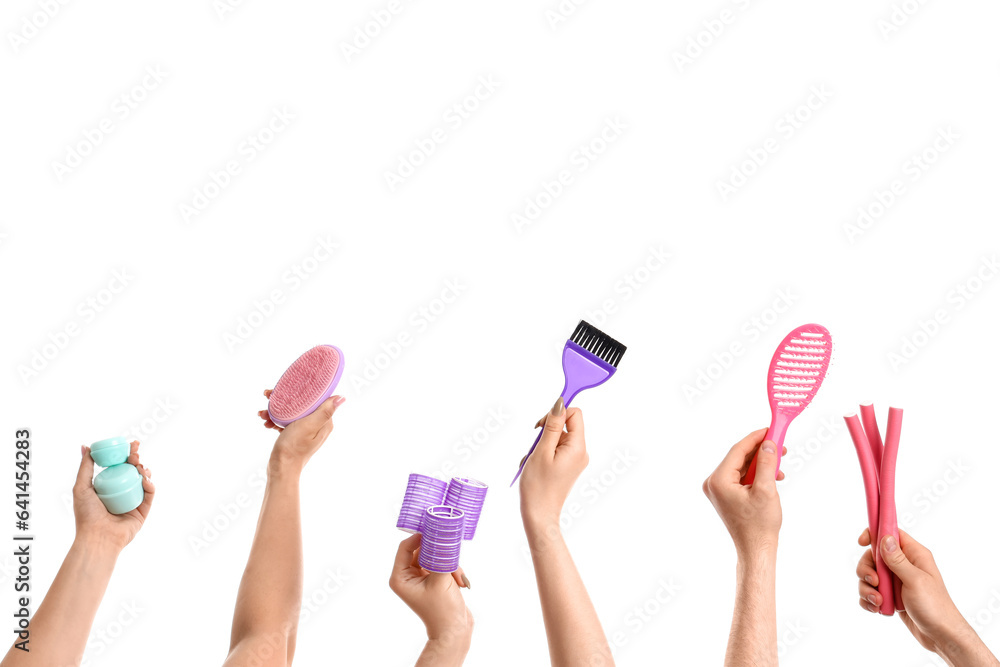 Many hands with different hairdressing supplies isolated on white background