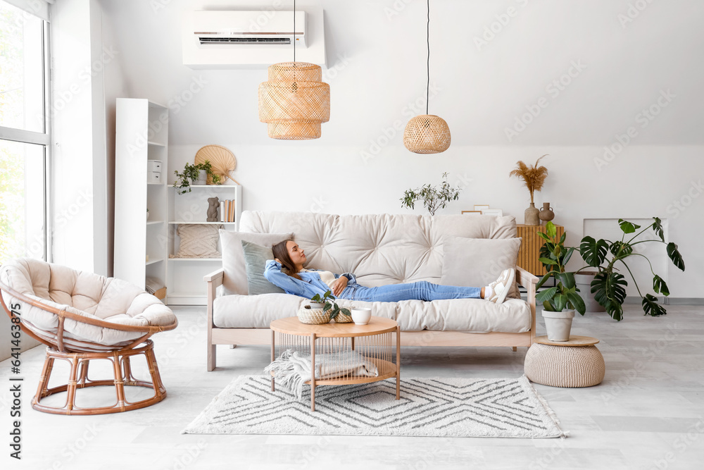 Young woman lying on couch in living room