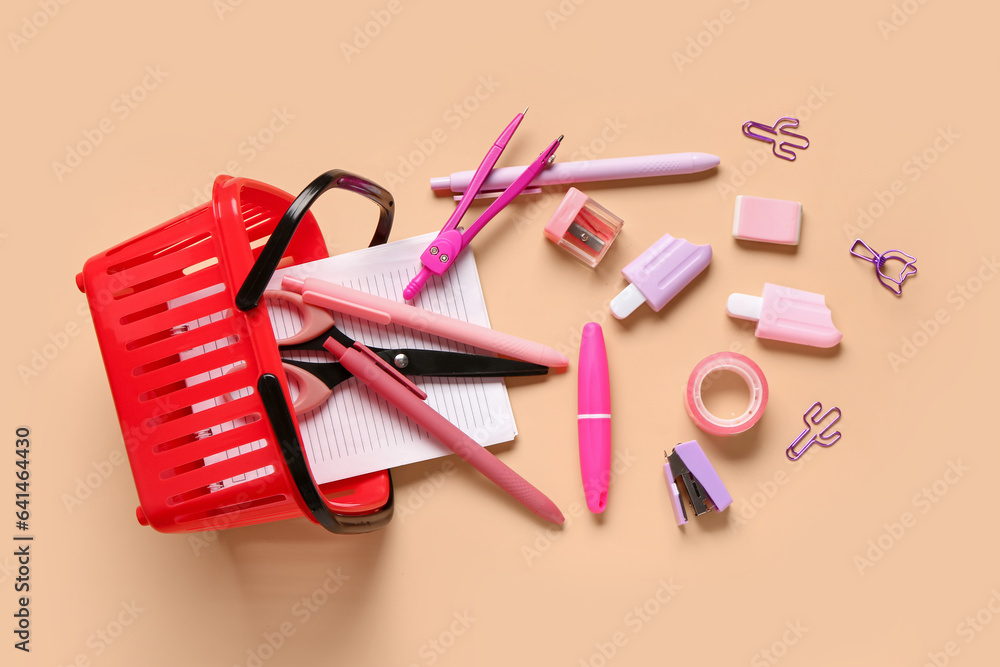 Composition with shopping basket and stationery on color background