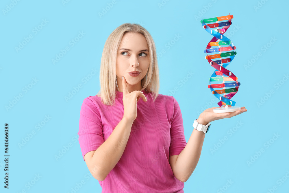 Thoughtful young beautiful woman with molecular model on blue background