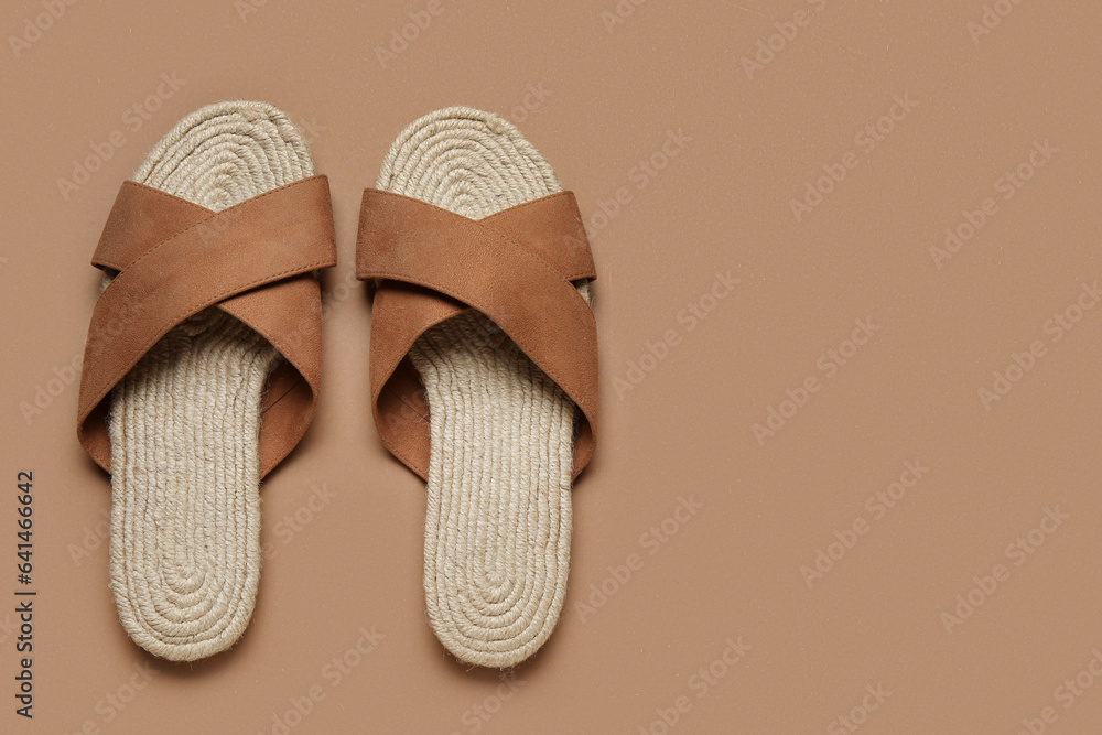 Stylish brown sandals on color background