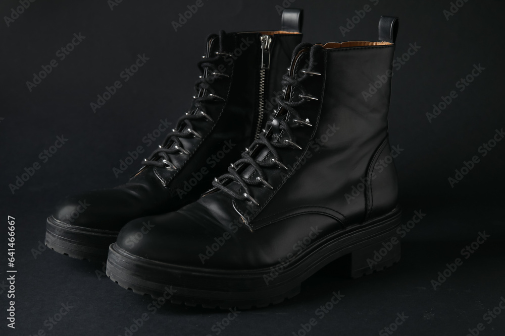 Stylish leather boots on black background