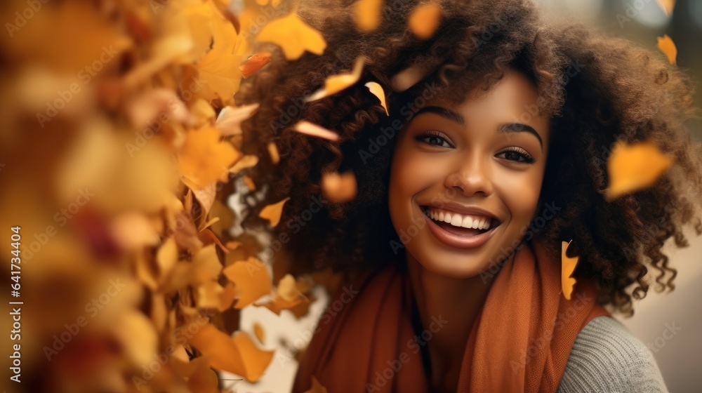 Beautiful black woman smiling in autumn leaves, Orange autumn tones.