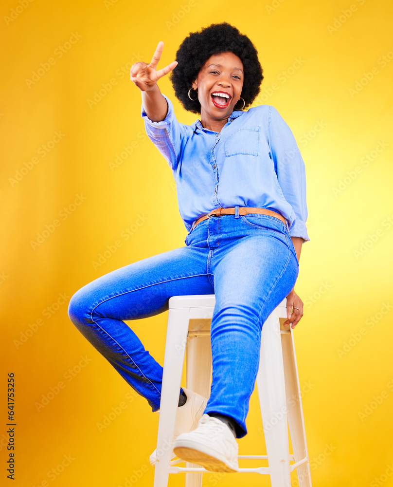 Black woman, peace and sign with hands on chair in studio, yellow background or natural happiness wi