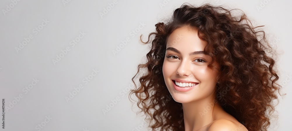 Model girl with shiny brown smooth healthy hair with long curly hair and glowing, skin natural beaut