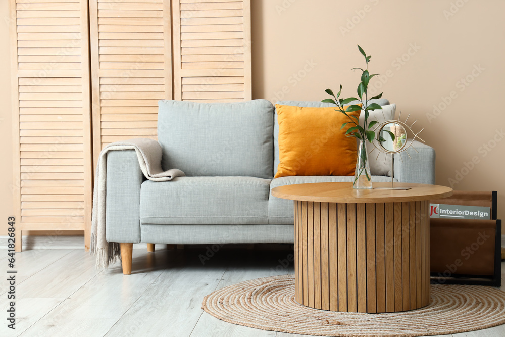 Interior of living room with grey sofa, coffee table and folding screen