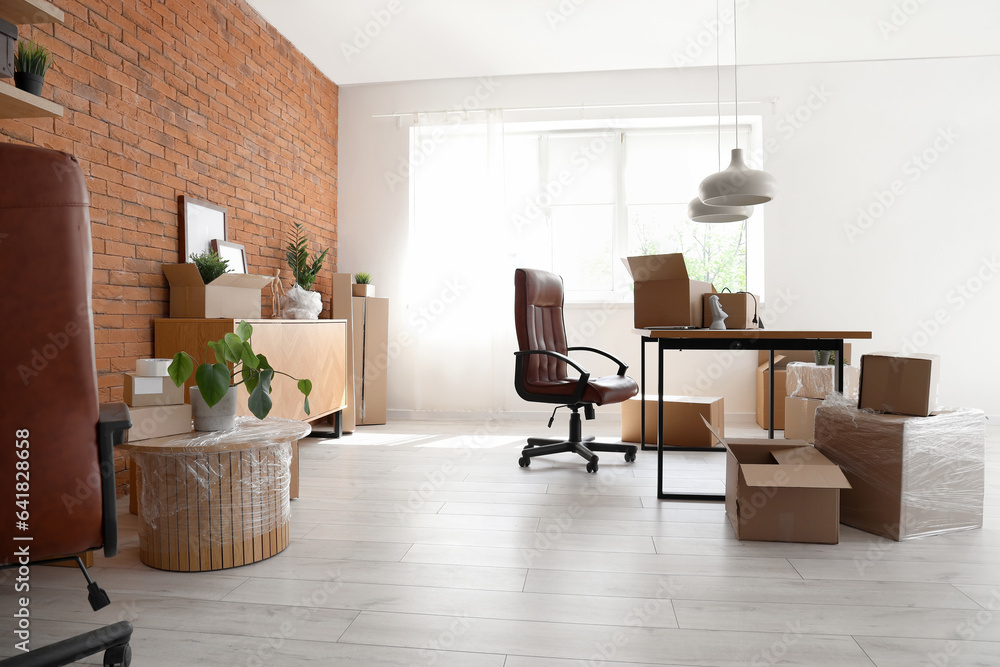 Interior of stylish office with cardboard boxes on moving day