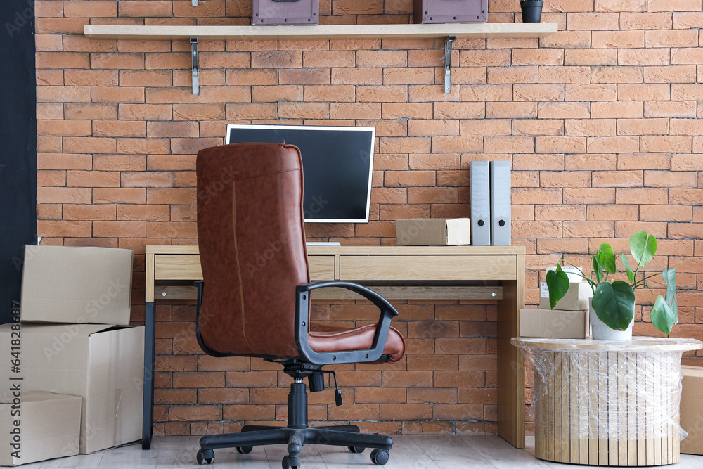 Interior of stylish office with cardboard boxes on moving day