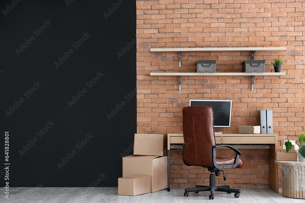 Interior of stylish office with cardboard boxes on moving day