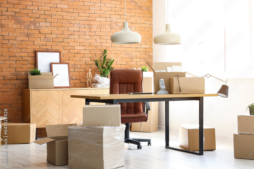 Interior of stylish office with cardboard boxes on moving day