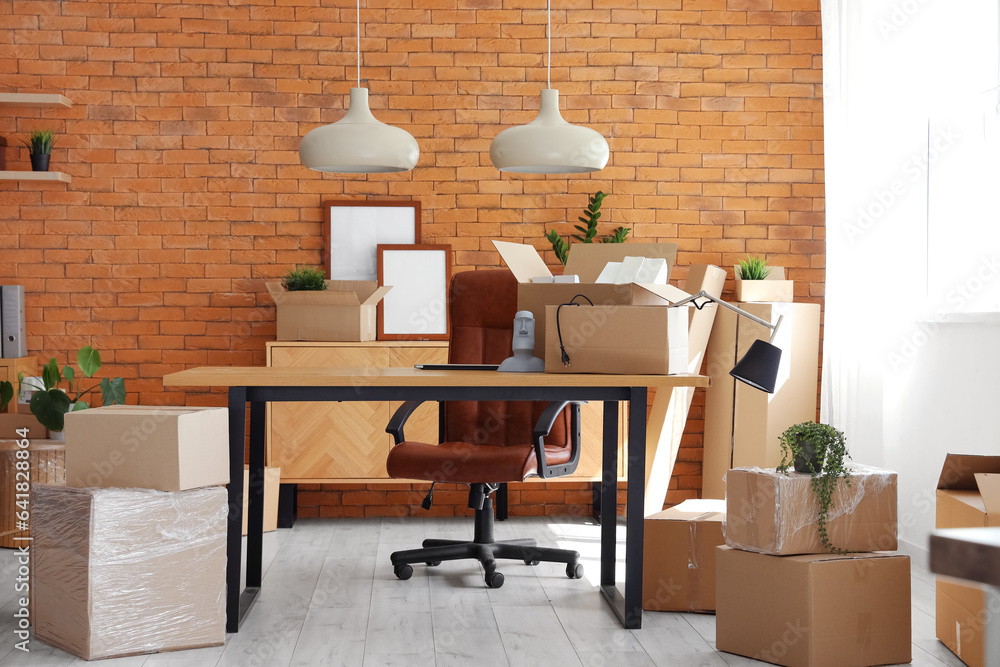 Interior of stylish office with cardboard boxes on moving day