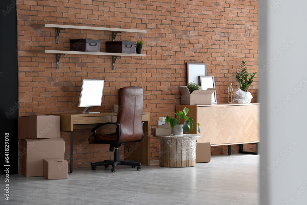 Interior of stylish office with cardboard boxes on moving day