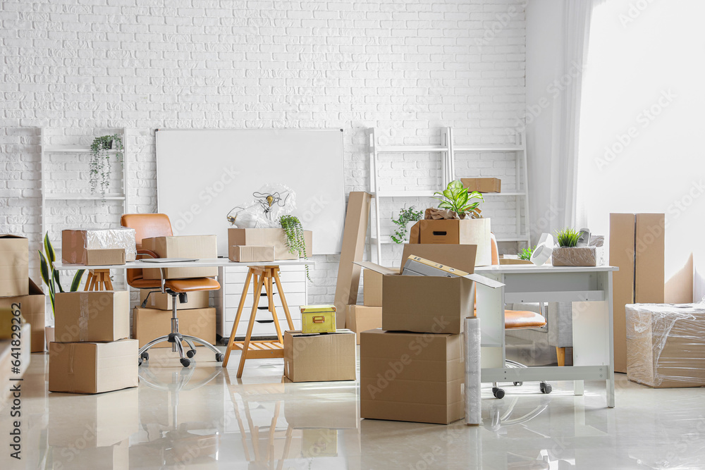 Workplaces with cardboard boxes in office on moving day