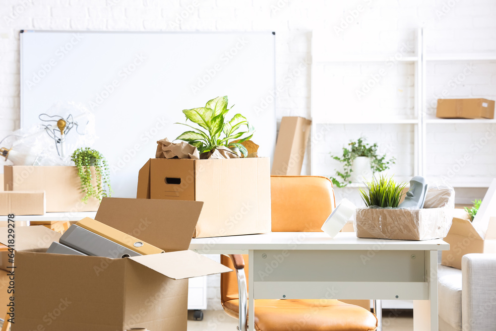 Workplace with cardboard boxes in office on moving day