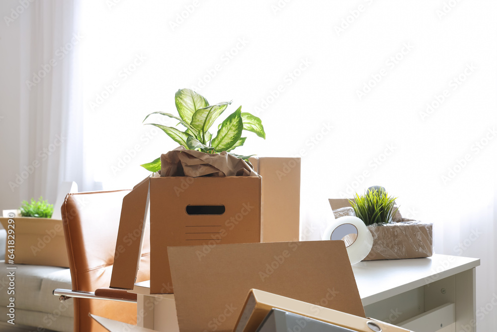 Workplace with cardboard boxes in office on moving day