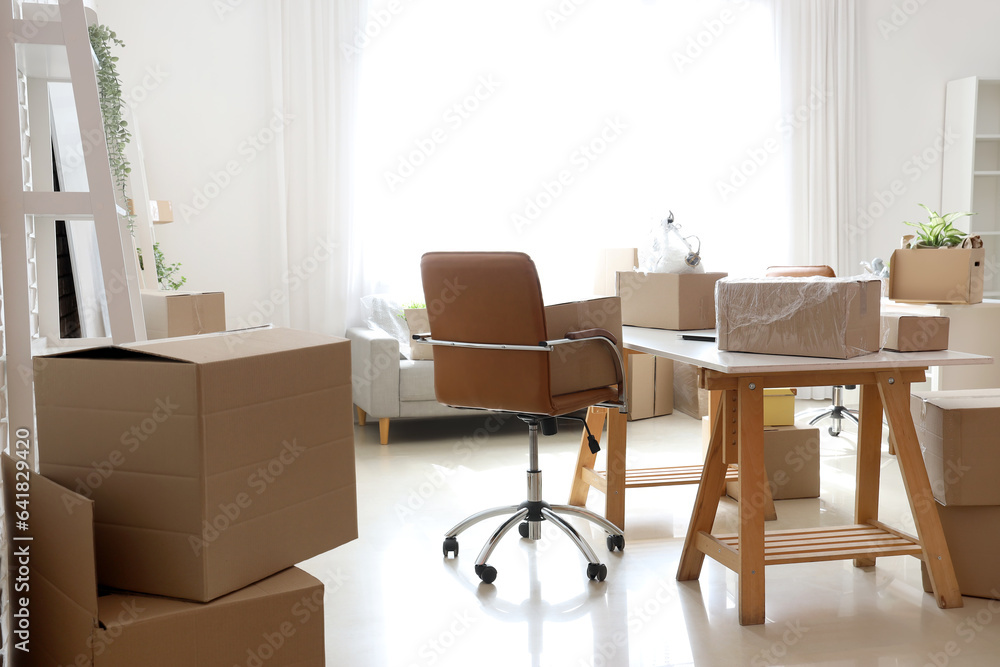 Modern workplace with cardboard boxes in office on moving day