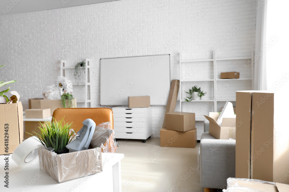 Modern workplace with cardboard boxes in office on moving day