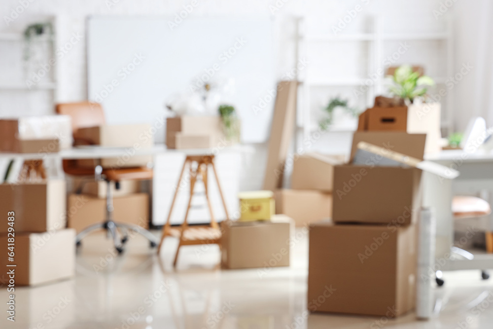 Blurred view of office with cardboard boxes on moving day