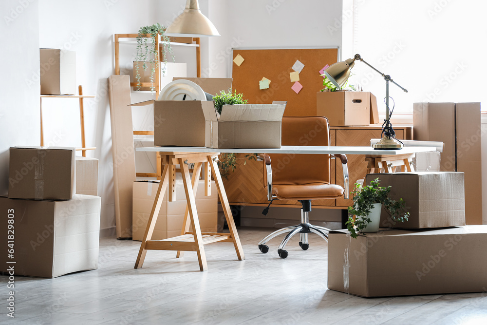 Modern workplace with cardboard boxes in office on moving day