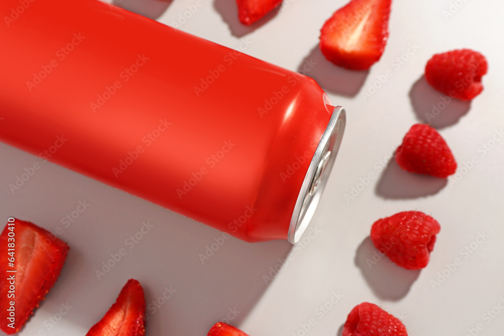 Composition with can of fresh soda and strawberry on grey background, closeup