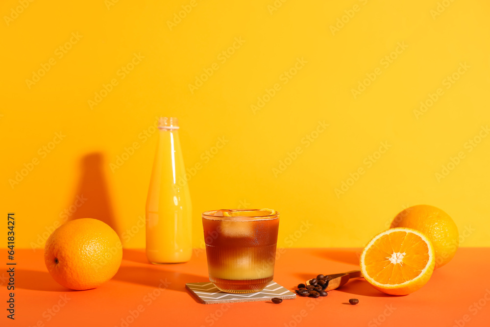 Glass of tasty orange espresso on color background