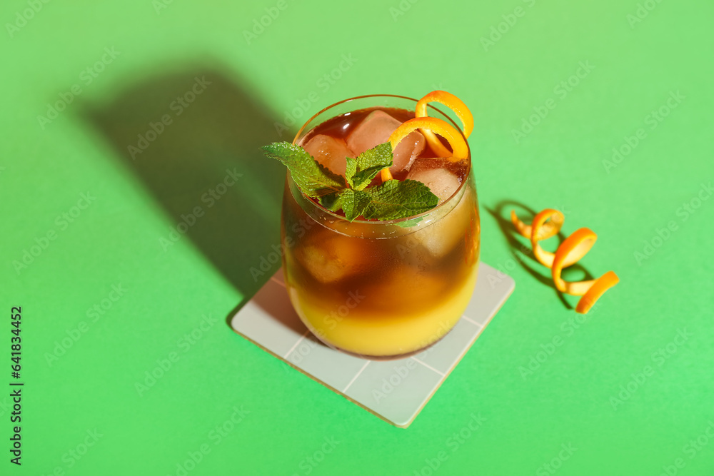 Glass of tasty orange espresso on color background