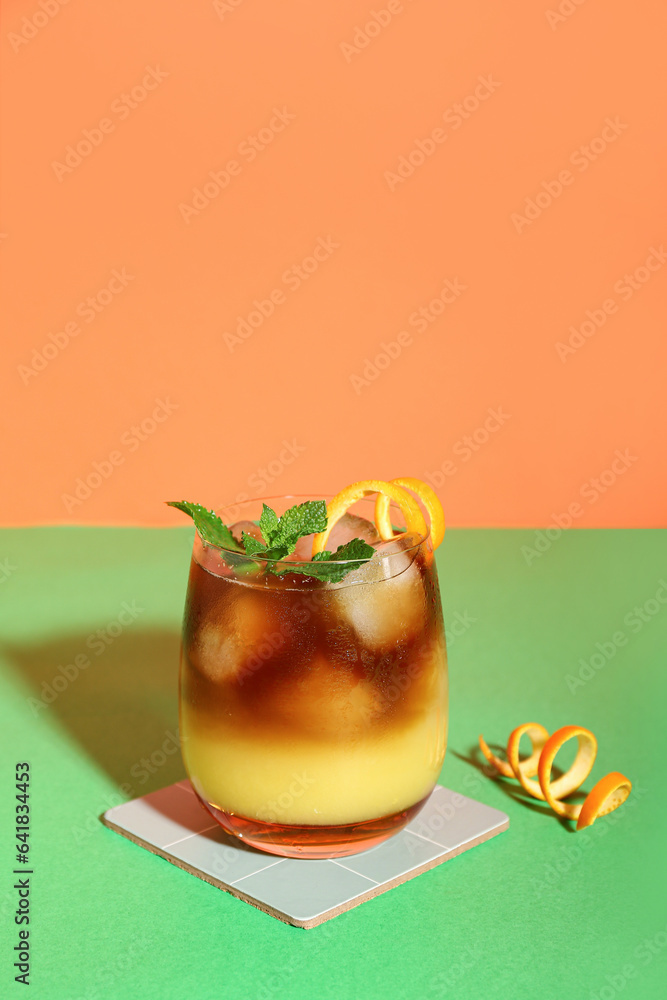 Glass of tasty orange espresso on color background