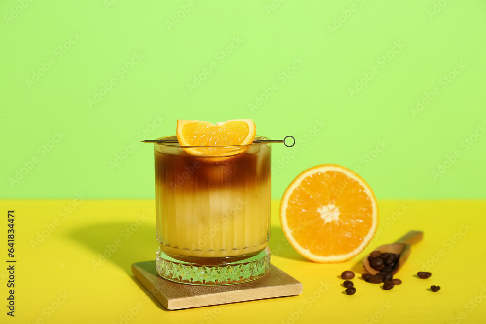 Glass of tasty orange espresso on color background