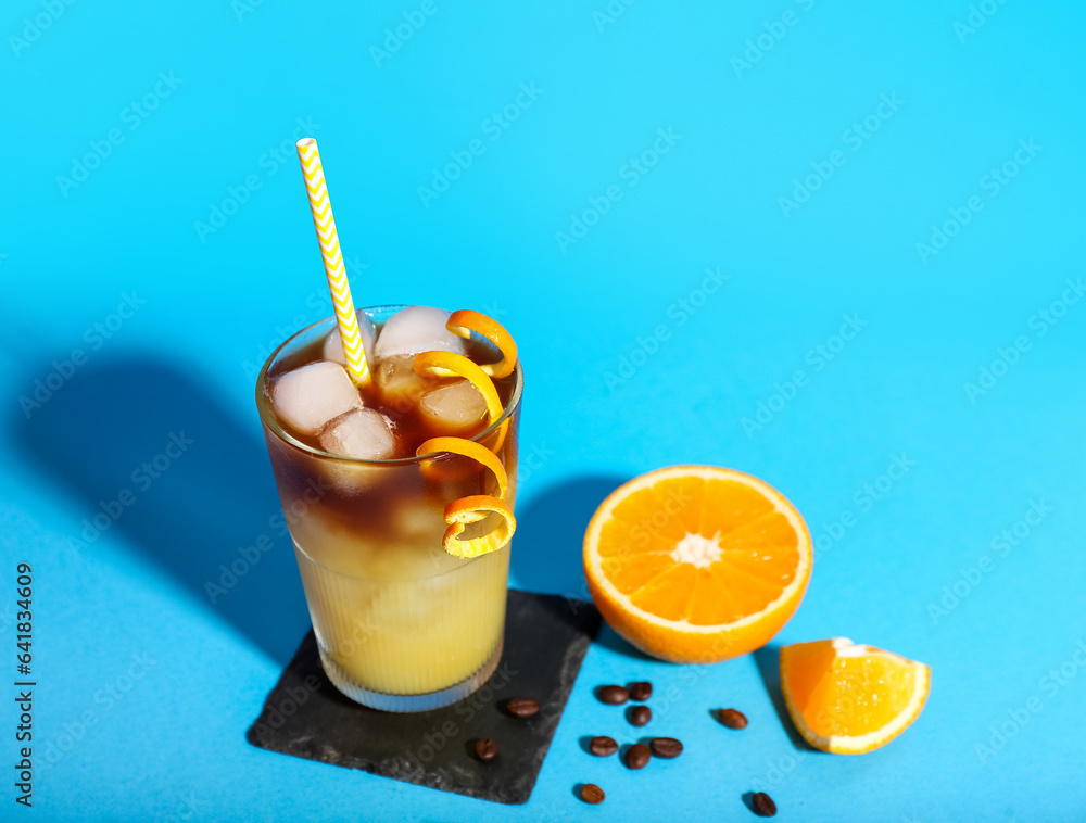 Glass of tasty orange espresso on blue background