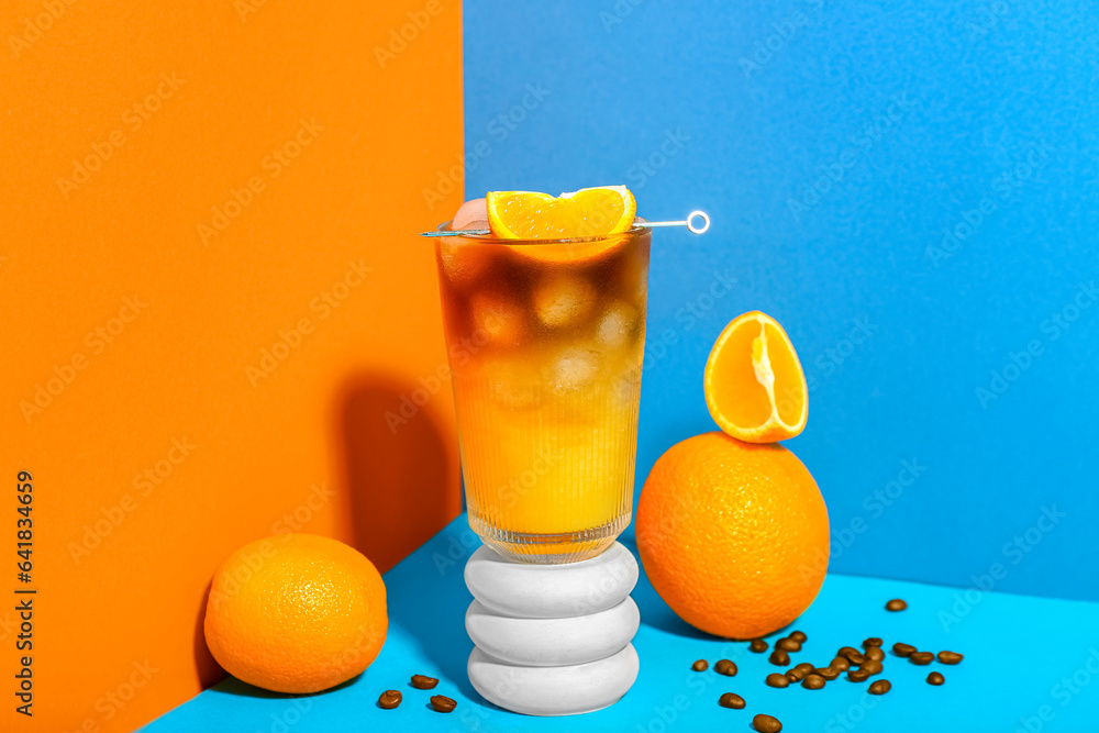 Glass of tasty orange espresso on color background