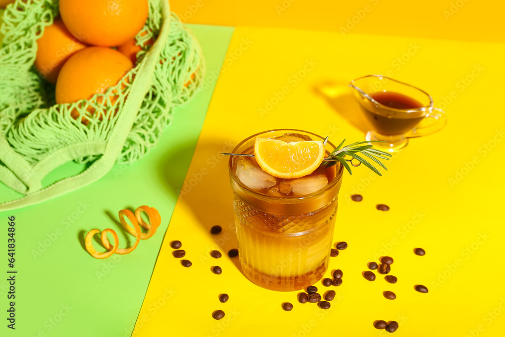 Glass of tasty orange espresso on color background