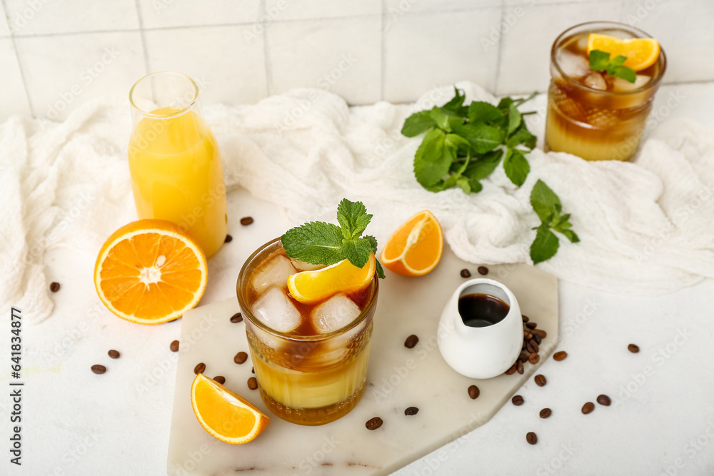 Glasses of tasty orange espresso and ingredients on table