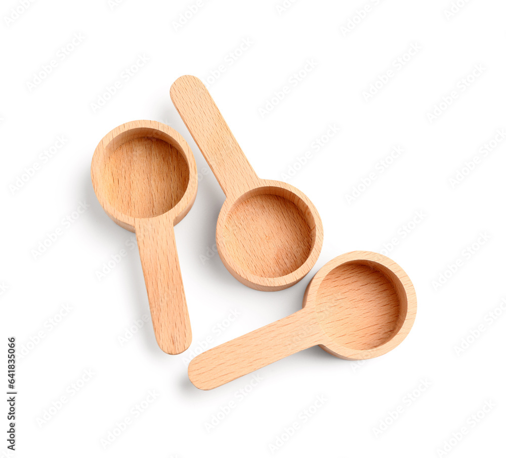 Empty wooden scoops on white background