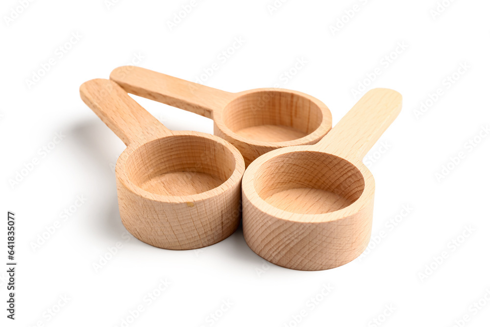 Empty wooden scoops on white background