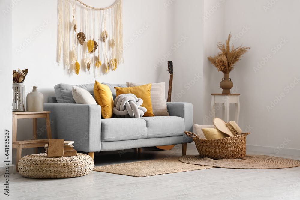 Interior of light living room with sofa and wicker basket