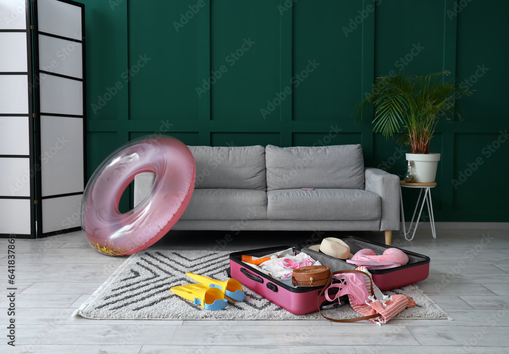 Interior of living room with suitcase and beach accessories