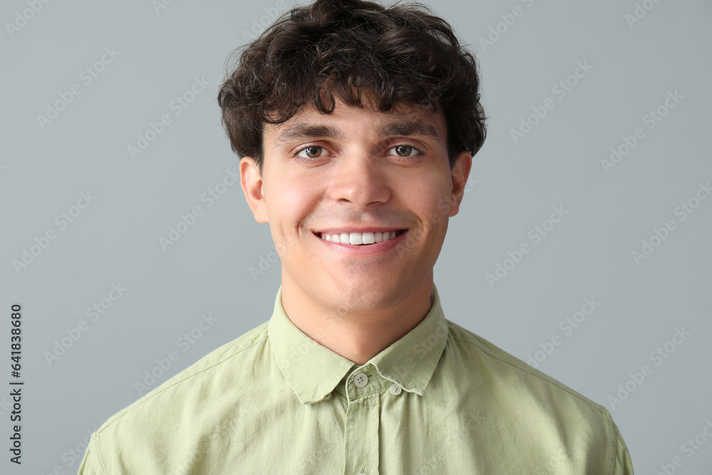 Portrait of smiling young man on grey background