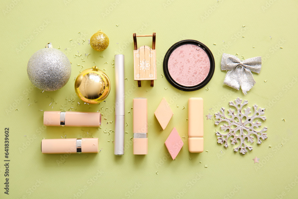 Composition with decorative cosmetics and Christmas decor on light yellow background